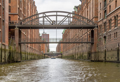 Bridge over canal amidst buildings in city