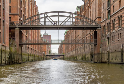 Bridge over canal amidst buildings in city