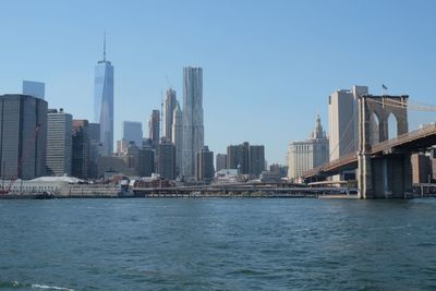 Brooklyn bridge over east river against city