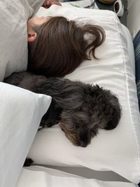 High angle view of women and dog sleeping on bed at home