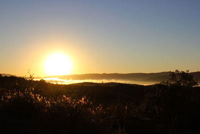 Scenic view of silhouette landscape against clear sky during sunset