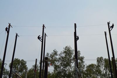 Low angle view of power lines against clear sky