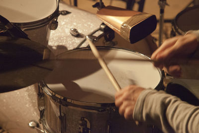 Cropped hands of man playing drums