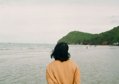 Rear view of woman looking at sea against sky