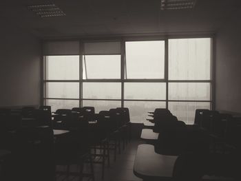 Silhouette of man sitting on table by window