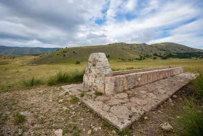 Old ruins on field against sky