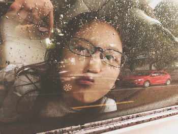 Close-up portrait of wet glass window