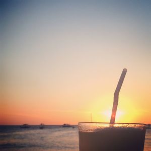 Close-up of sea against clear sky at sunset