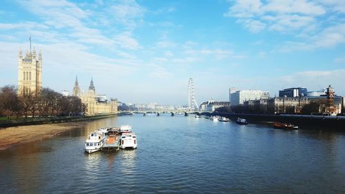 Boats in river with city in background