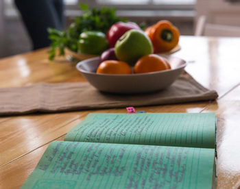 Spices and old recipe book on wooden background on kitchen.