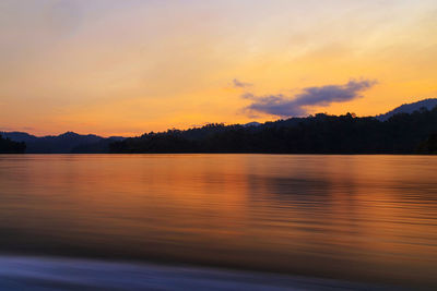 Scenic view of lake against orange sky