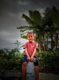 Portrait of happy boy smiling against sky