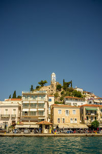 Buildings in city against clear blue sky