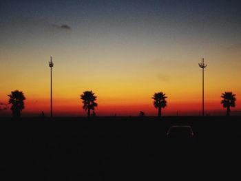 Silhouette palm trees against sky at sunset