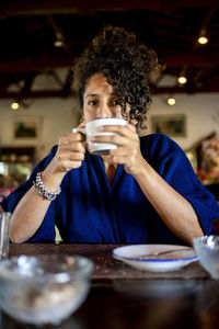 Relaxed woman smiling and drinking a cup of coffee