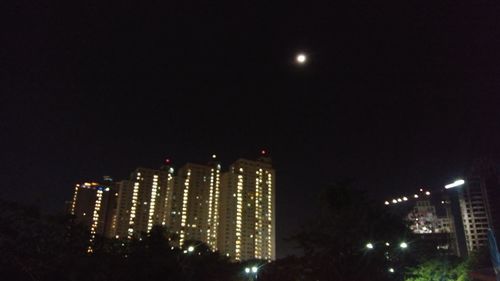 Illuminated city against sky at night