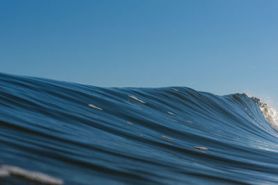 Low angle view of a wave against clear blue sky
