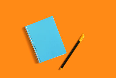 High angle view of pen against orange background