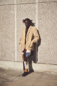 Full length of young black man standing against wall