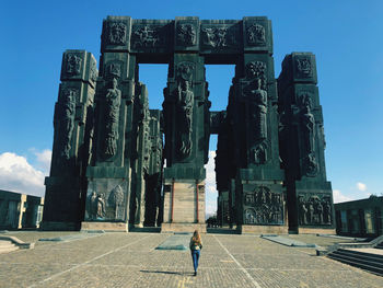 Rear view of woman standing by built structure