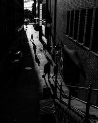 People walking on street amidst buildings in city