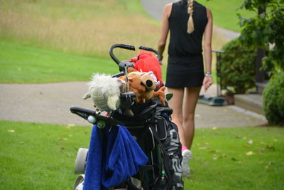 Stuffed toys in golf bag with woman walking in background