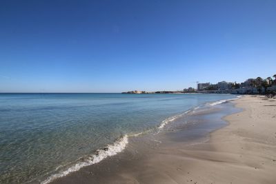 Scenic view of beach against clear blue sky