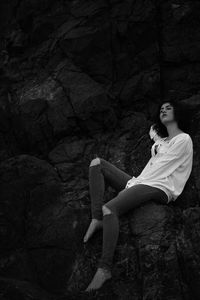 Portrait of woman sitting on rock