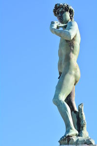 Low angle view of statue against blue sky