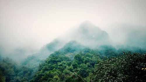 Scenic view of mountains against sky during foggy weather