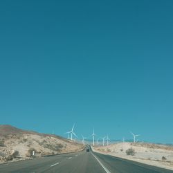 Road against clear blue sky