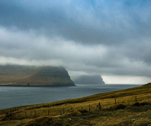 Scenic view of sea and mountains against sky