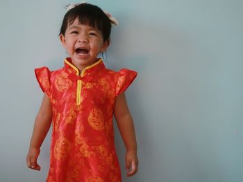 Happy girl standing against red background