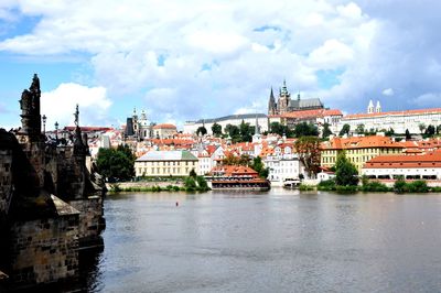 Arch bridge over river against buildings in city