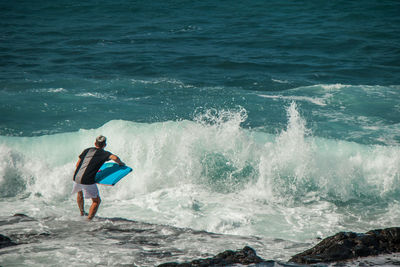 Rear view of man surfing in sea