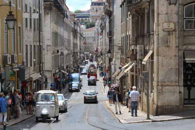 People on street amidst buildings in city