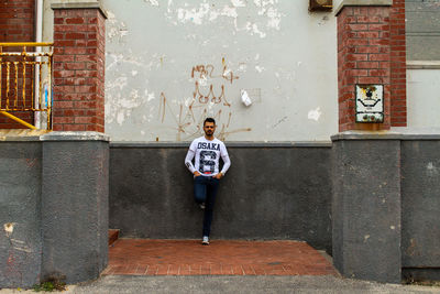 Full length of boy standing against building