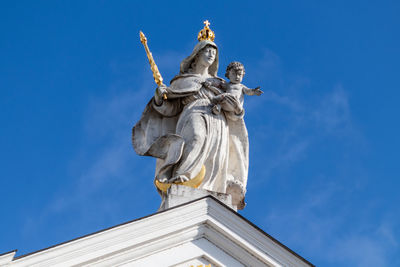 Statue with golden scepter and crown on st. stephen's cathedral in passau, bavaria, germany