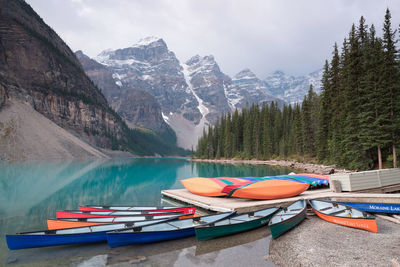 Boats moored on lake against mountains