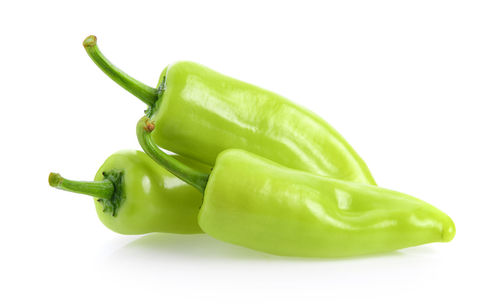 Close-up of green chili pepper against white background
