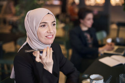 Portrait of young woman wearing hijab in cafe