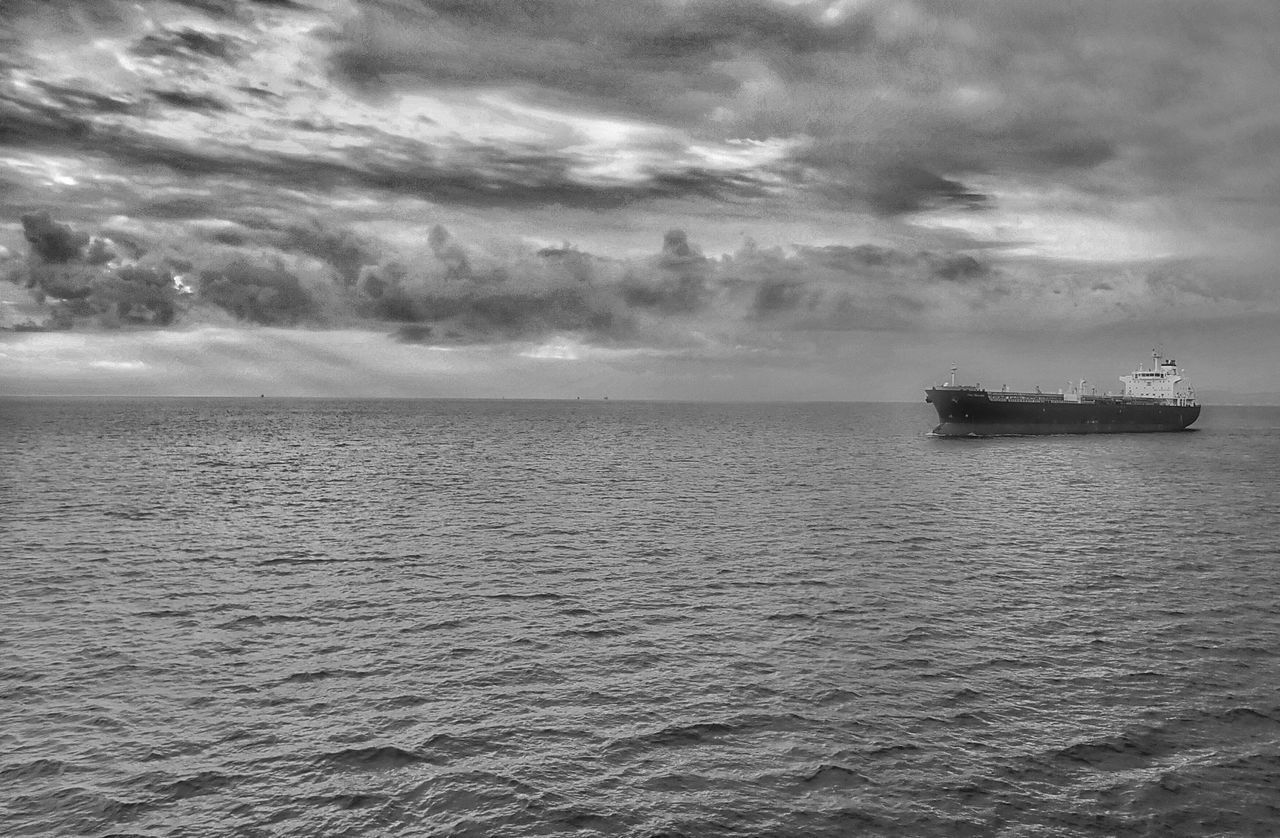 BOAT IN SEA AGAINST STORM CLOUDS