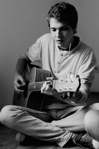 Young playing guitar at home