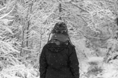 Rear view of man standing on snow covered land