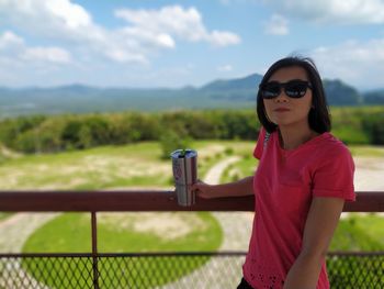 Portrait of young woman wearing sunglasses standing outdoors