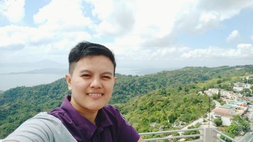 Portrait of smiling man against mountains against sky