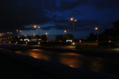Illuminated street light against sky at night
