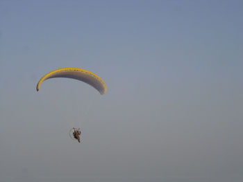 Low angle view of hang-gliding against clear sky