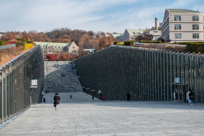 People walking on street amidst buildings in city