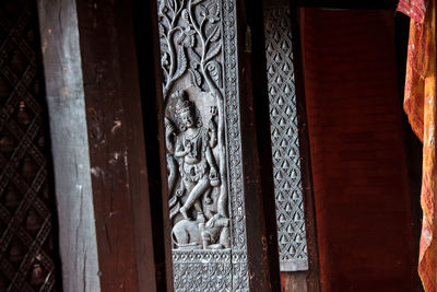 Close-up of buddha statue against door